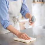 A woman is cleaning in the kitchen.