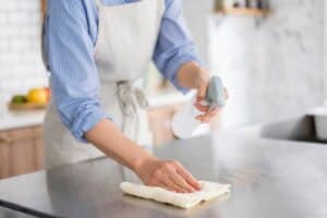 A woman is cleaning in the kitchen.