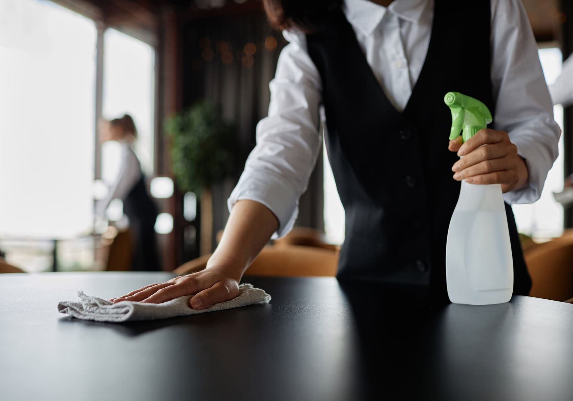 Close up of server wiping dining table