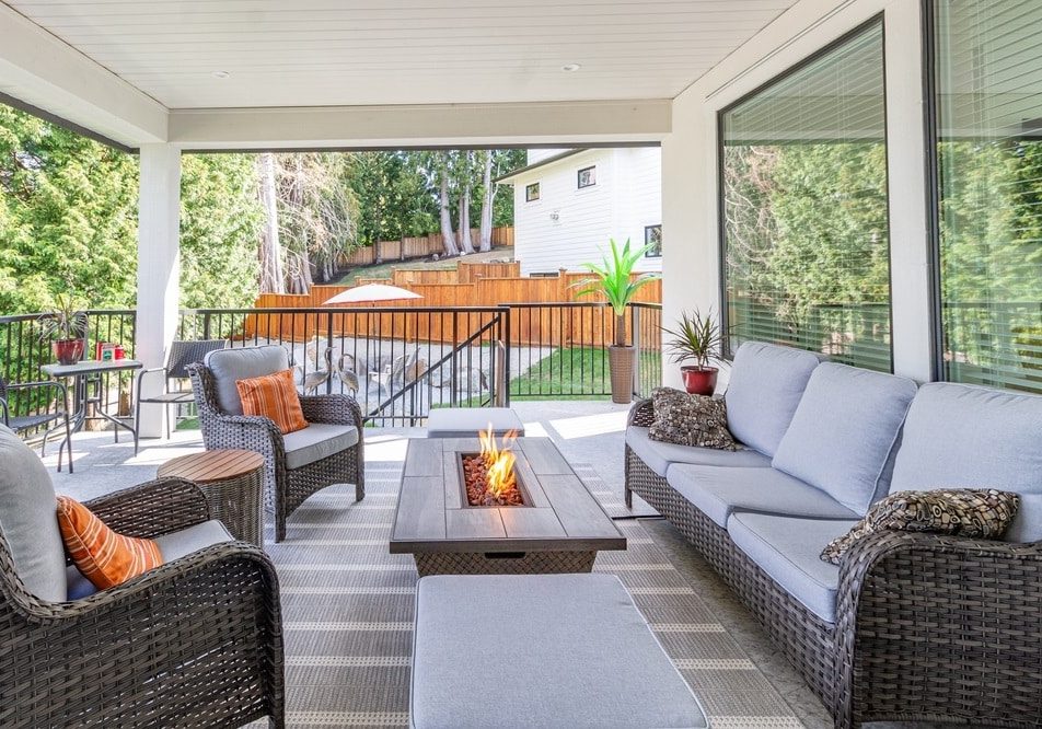 A luxurious spacious deck with stylish patio furniture with a fire pit table heater A luxurious spacious deck with stylish patio furniture with a fire pit table heater