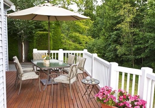 Outdoor patio setup on cedar wood deck with trees in background