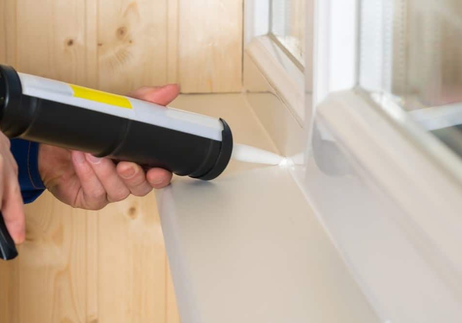 sealing cracks of plastic windows with the help of white silicon