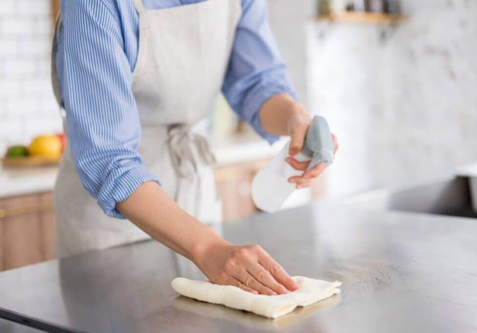 A woman is cleaning in the kitchen.