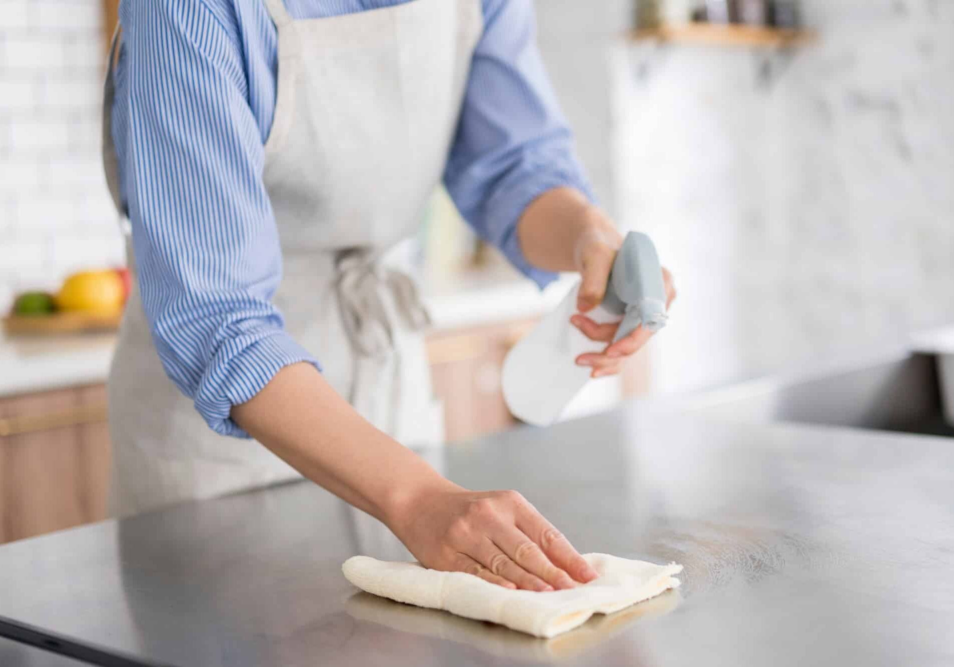 A woman is cleaning in the kitchen.